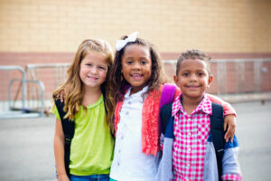 Children standing together in school setting.