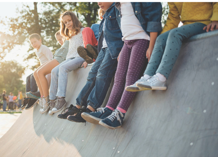 Group of children sitting on wall.