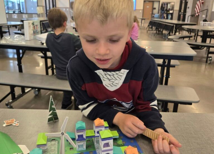 Boy looking at toys on table.