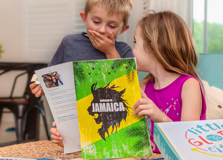 Two children reading packet about Jamacia
