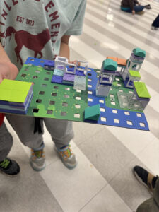 Child holding a handmade building creation.