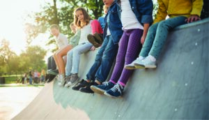 Group of children sitting on wall.