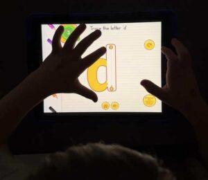 Child's hands on tablet lesson.