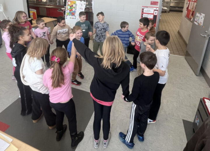 Kids in a group holding hands.