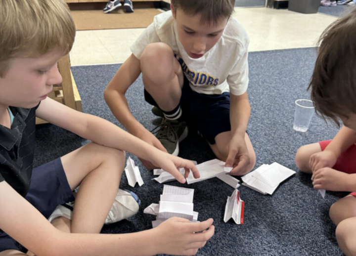 Boys playing with a paper activity.