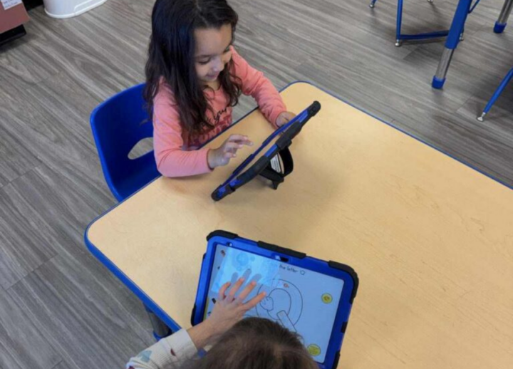 Two children using iPads