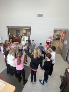 Kids in a group holding hands.