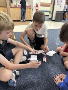 Boys playing with a paper activity.
